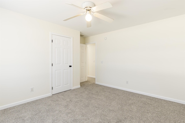 spare room with ceiling fan and light colored carpet