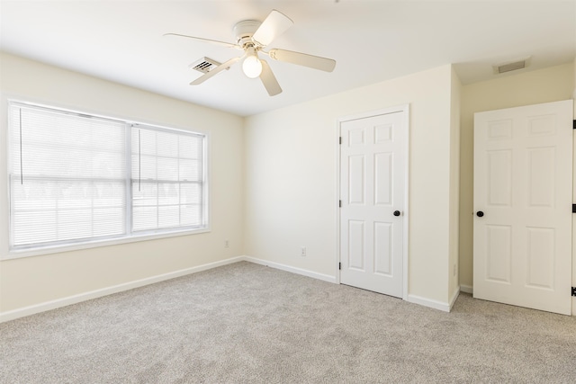 unfurnished bedroom featuring light carpet and ceiling fan