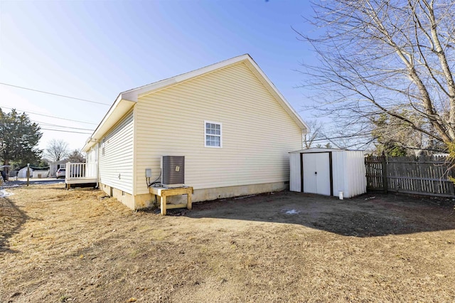 back of house with a storage shed