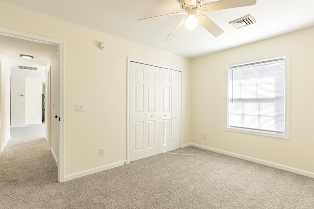 unfurnished bedroom with ceiling fan, a closet, and light carpet