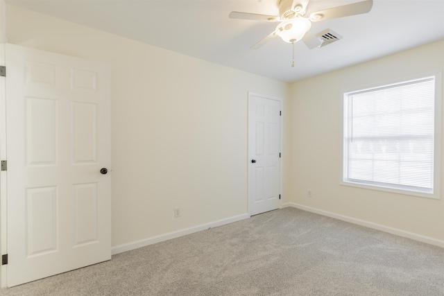 spare room featuring light carpet and ceiling fan