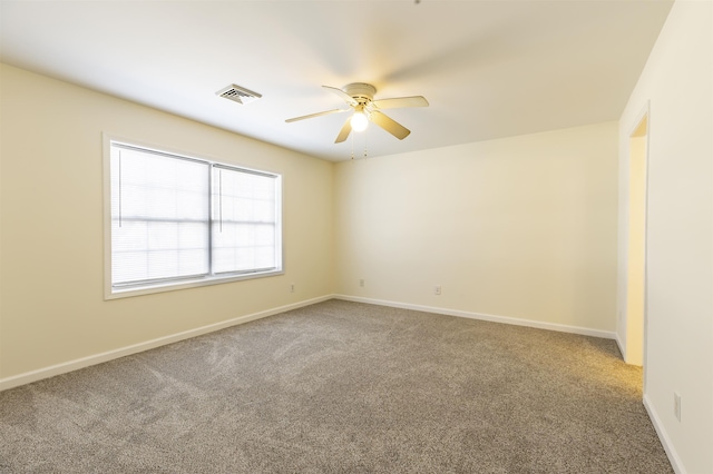 carpeted spare room with ceiling fan