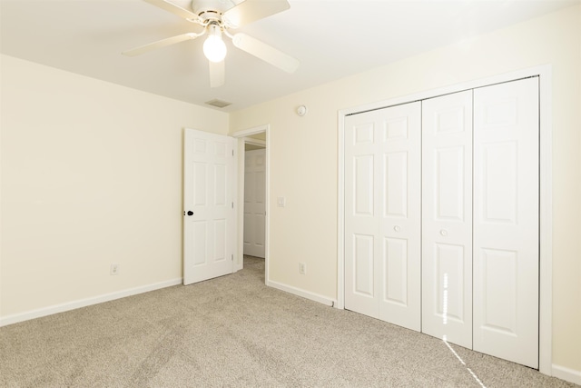 unfurnished bedroom featuring light carpet, ceiling fan, and a closet