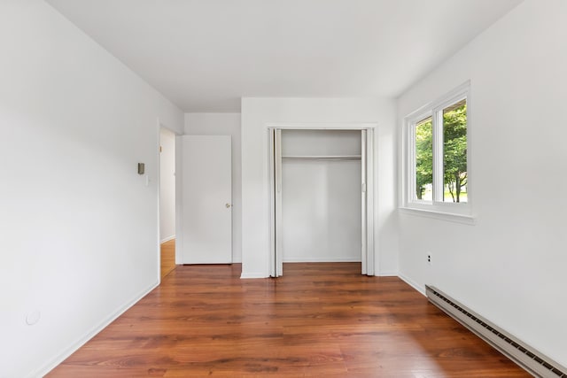 1 Cypress Ct, Rio Grande, NJ 08242 - unfurnished bedroom featuring baseboard heating, wood finished floors, a closet, and baseboards
