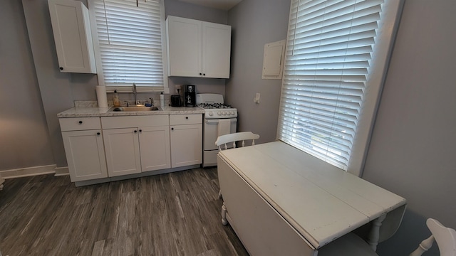 kitchen with dark hardwood / wood-style floors, white cabinetry, white gas range, and sink