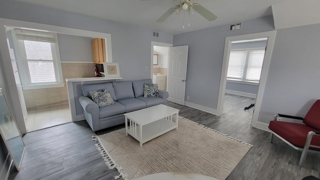 living room with dark hardwood / wood-style flooring and ceiling fan