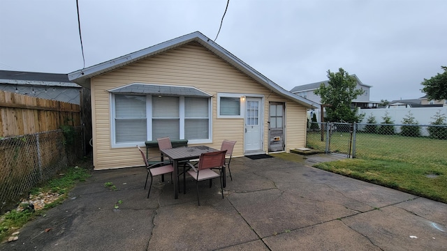 back of house with a lawn and a patio area