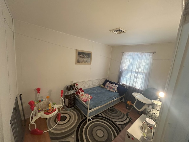 bedroom with wood finished floors and visible vents