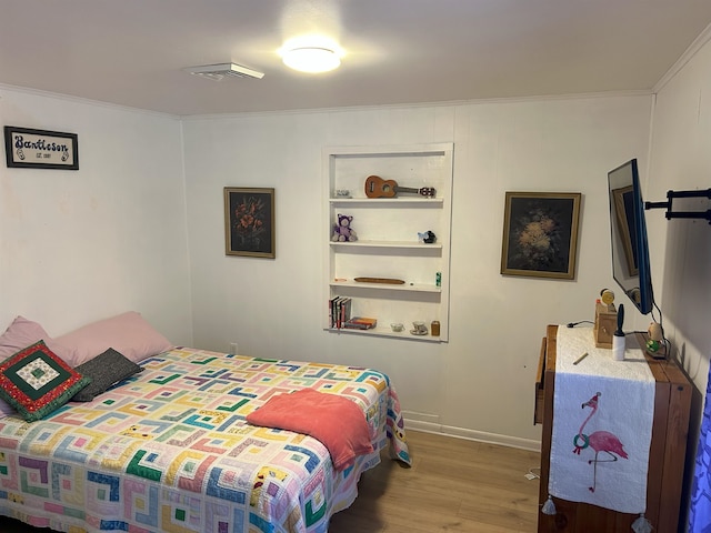 bedroom featuring light wood-style floors, visible vents, and crown molding