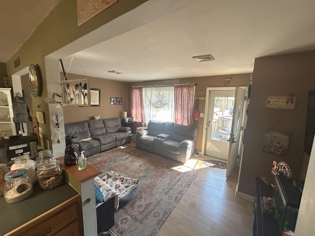 living room featuring visible vents and light wood-style flooring