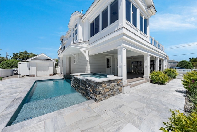 back of house featuring a patio area and a pool with hot tub