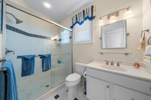 bathroom featuring tile patterned floors, vanity, toilet, and a shower with door