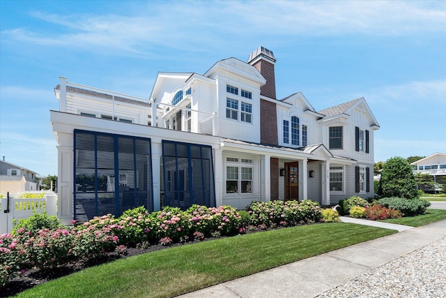 view of front of house with a balcony and a front yard