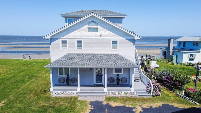 6 Pierces Point Rd, Cape May Court House, NJ 08210 - view of front facade with view of water and beach, a shingled roof, a front yard, and covered porch