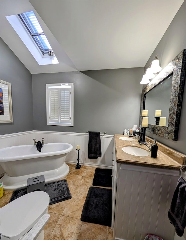 6 Pierces Point Rd, Cape May Court House, NJ 08210 - full bath featuring a skylight, vaulted ceiling, a soaking tub, double vanity, and wainscoting
