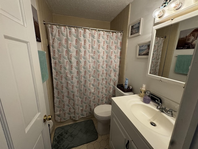 bathroom with vanity, a textured ceiling, toilet, and tile patterned flooring