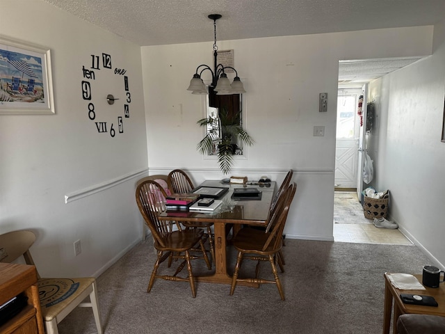 dining area with a textured ceiling, light carpet, and an inviting chandelier