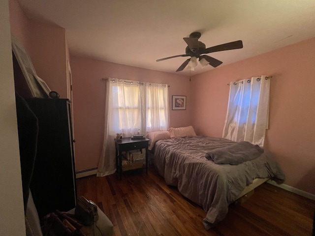 bedroom with ceiling fan, dark hardwood / wood-style floors, and a baseboard radiator