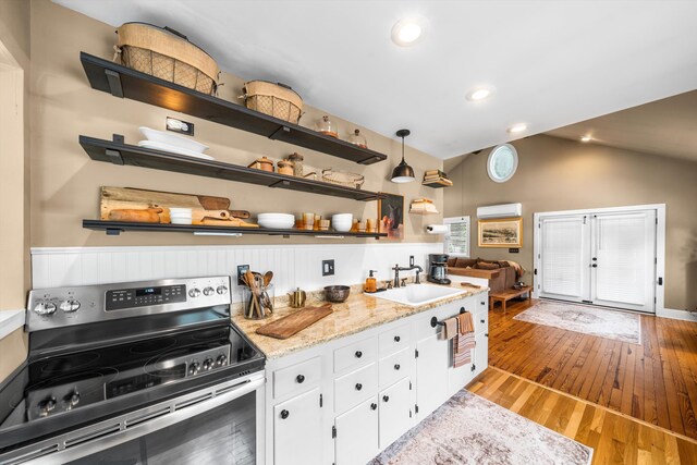 2068 N Shore Rd, Clermont, NJ 08210 - kitchen featuring stainless steel range with electric stovetop, a wall mounted air conditioner, vaulted ceiling, light wood-type flooring, and white cabinets