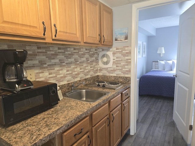 kitchen with dark hardwood / wood-style flooring, tasteful backsplash, electric cooktop, and sink