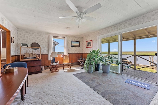 interior space with ceiling fan, a water view, and a baseboard heating unit