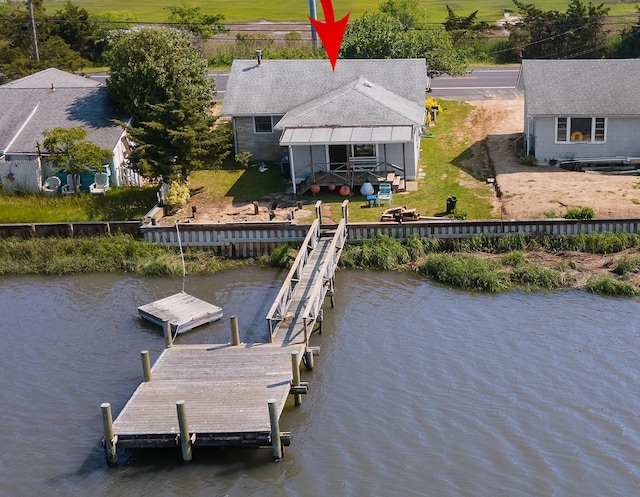 view of dock with a yard and a water view