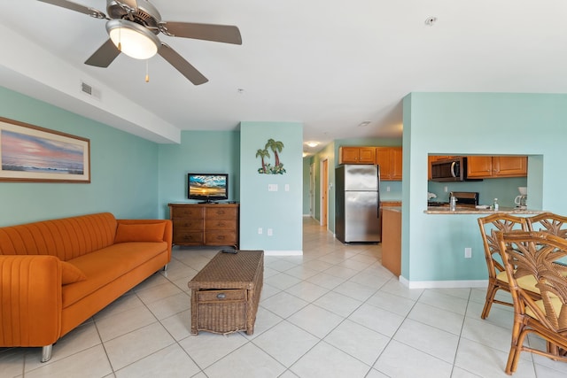 living room featuring ceiling fan, sink, and light tile patterned floors