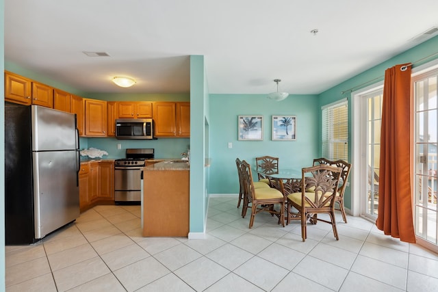 kitchen featuring pendant lighting, light tile patterned floors, sink, and appliances with stainless steel finishes