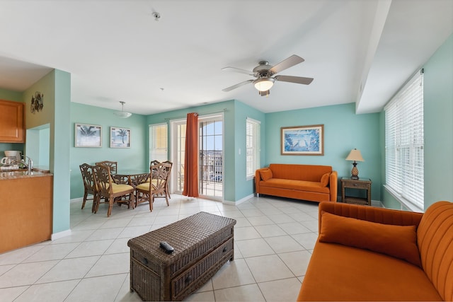 living room featuring ceiling fan, light tile patterned floors, and sink