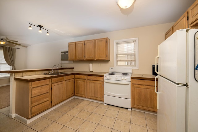 kitchen featuring white appliances, sink, ceiling fan, light tile patterned floors, and kitchen peninsula