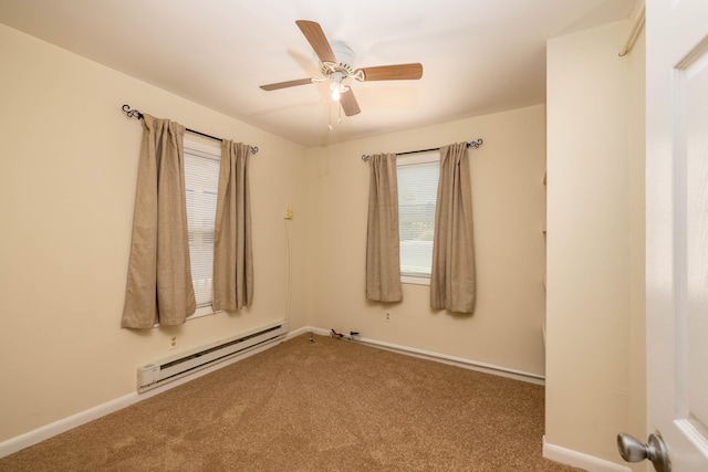 spare room with carpet flooring, ceiling fan, and a baseboard heating unit