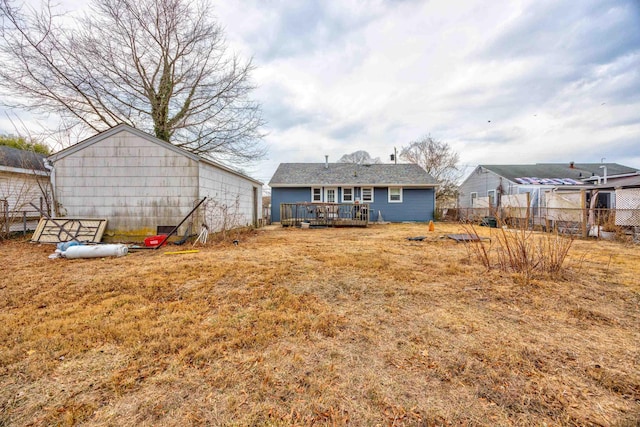 rear view of property featuring fence and a wooden deck