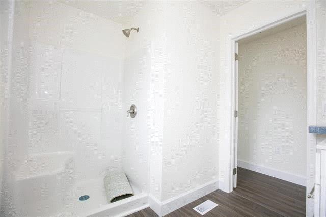 bathroom with hardwood / wood-style flooring and a shower