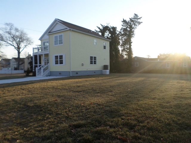 back of house featuring cooling unit, a yard, and a balcony