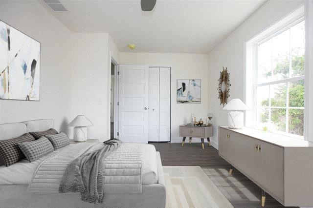 bedroom featuring ceiling fan, dark hardwood / wood-style flooring, and a closet