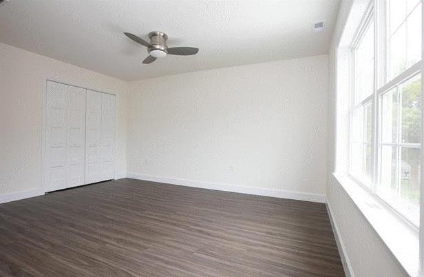 unfurnished bedroom with dark wood-type flooring and ceiling fan