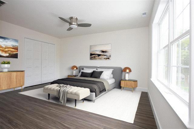 bedroom featuring hardwood / wood-style flooring, ceiling fan, and a closet