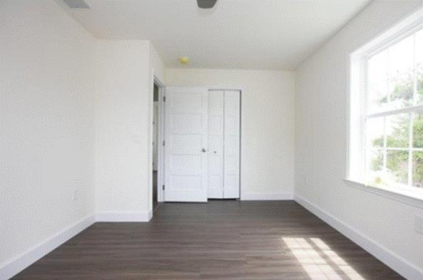 unfurnished bedroom featuring dark hardwood / wood-style flooring and a closet