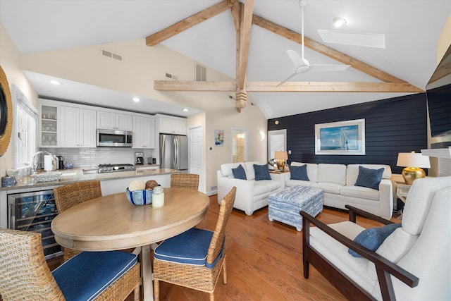 13 93rd St Unit 5, Stone Harbor, NJ 08247 - dining area with beverage cooler, light wood-style flooring, beam ceiling, a skylight, and high vaulted ceiling