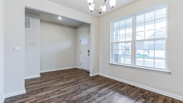 entryway with dark hardwood / wood-style flooring, a wealth of natural light, and a notable chandelier