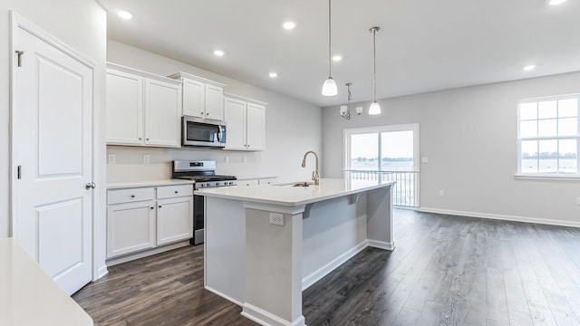 kitchen with white cabinets, stainless steel appliances, hanging light fixtures, and sink