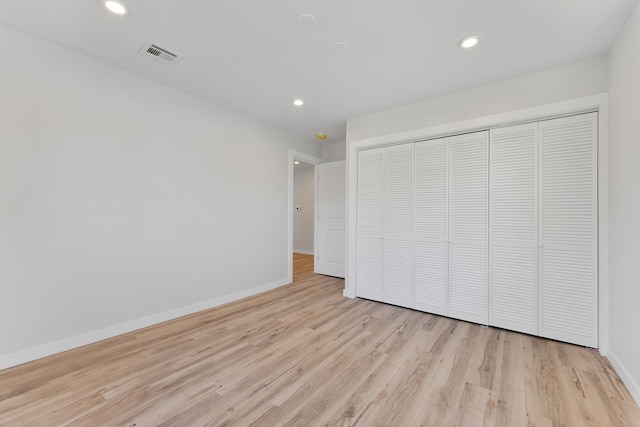 unfurnished bedroom with light hardwood / wood-style flooring and a closet