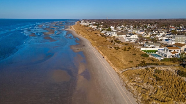 drone / aerial view with a water view and a beach view