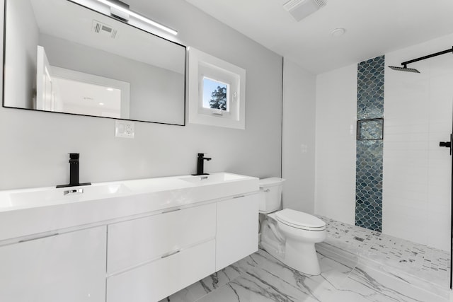 bathroom featuring tiled shower, vanity, and toilet