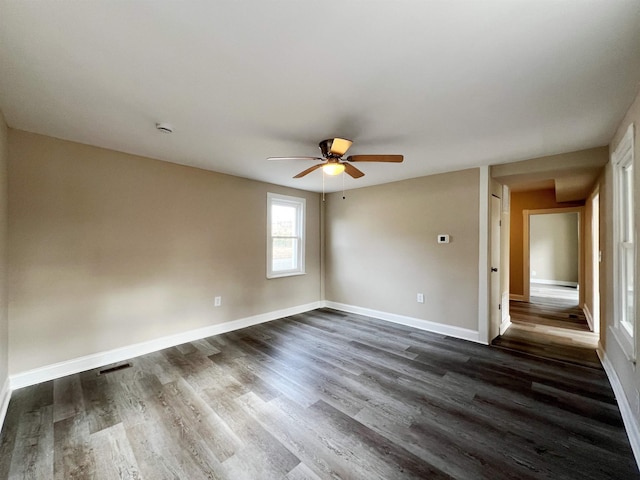 empty room with dark hardwood / wood-style floors and ceiling fan