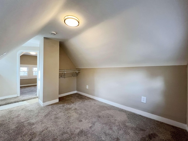 bonus room with lofted ceiling and carpet floors