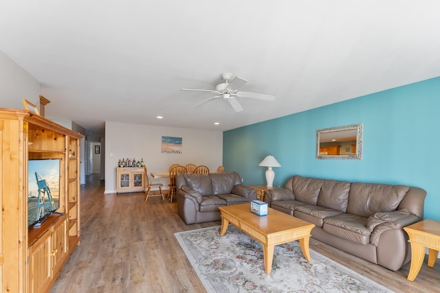 living room with ceiling fan and light hardwood / wood-style flooring