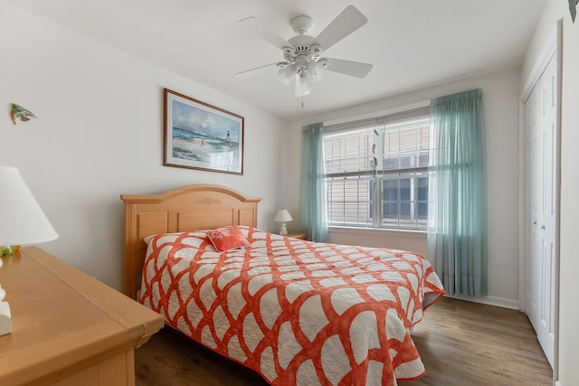 bedroom with dark wood-type flooring, a closet, and ceiling fan