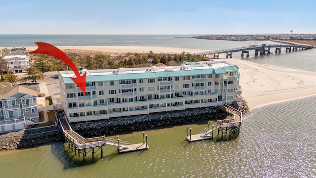 birds eye view of property featuring a water view and a beach view