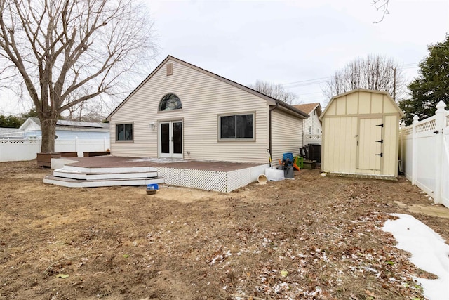 rear view of property featuring cooling unit, a storage shed, and a deck